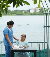 Female caregiver helping old women