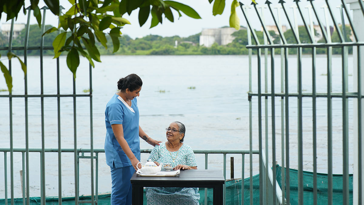 Female caregiver helping old women